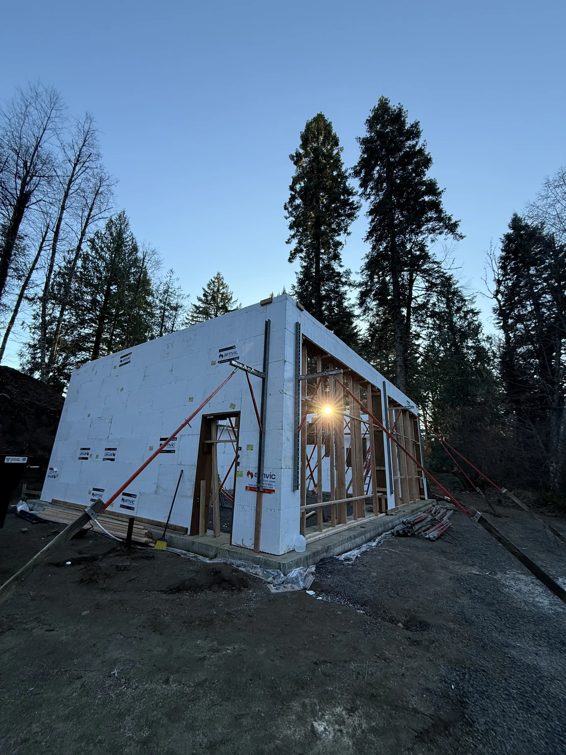 ICF walls and interior framing glowing at dusk with sun flare through the door opening